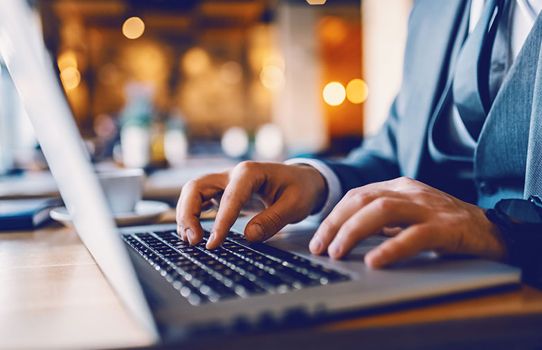 Closeup of a businessman's hands typing on a laptop