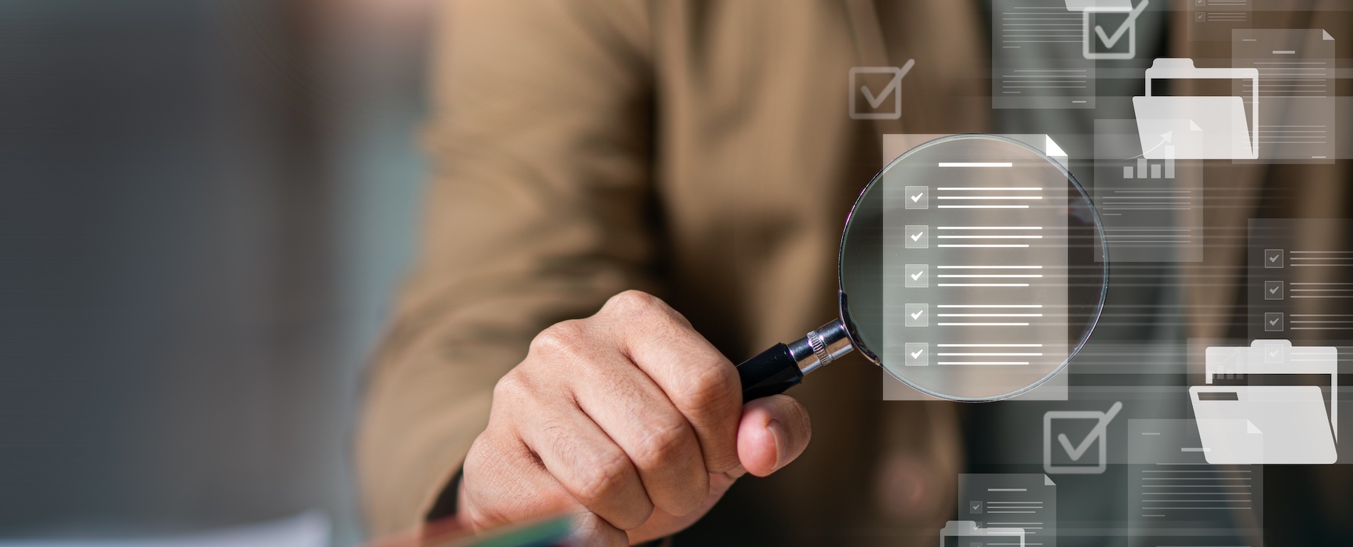 Person using a magnifying glass to review a digital checklist and document files