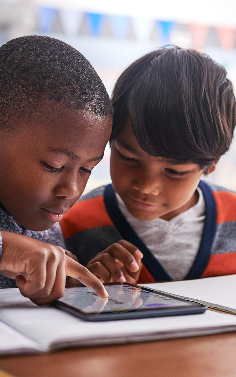 Two young children using an electronic tablet together