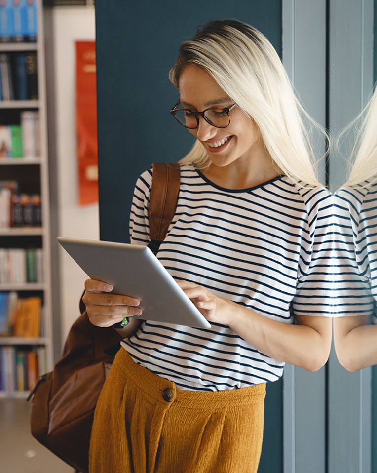 A smiling woman using a smart tablet.