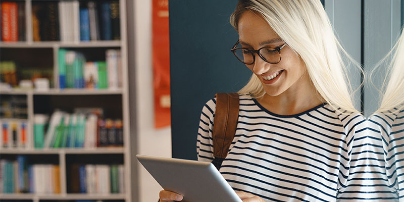 A smiling woman using a smart tablet.