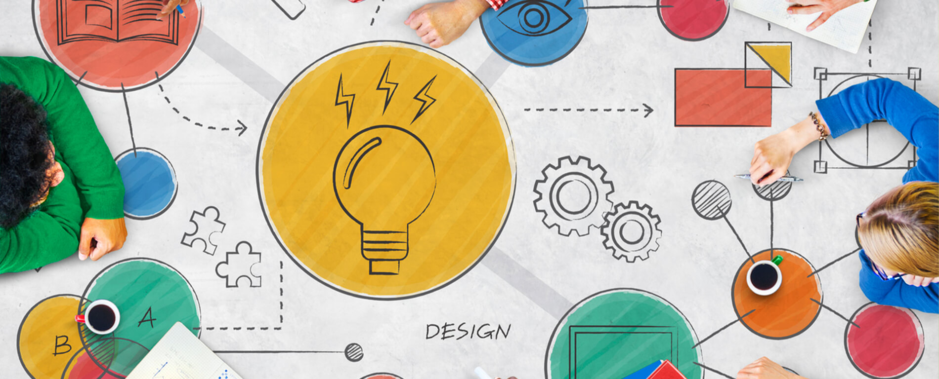 Top down view of people sitting at a conference table with design elements on top