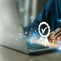 Hand on laptop with checkbox graphic