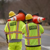 Flagger Forrce workers carrying orange cones