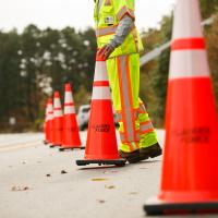 Orange construction cones on road with worker