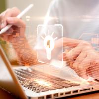 Hands on laptop with AI graphic