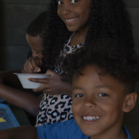 Three young children smiling at camp