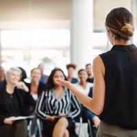 Woman teaching adults in classroom