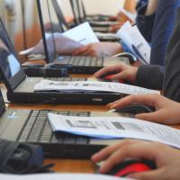 People's hands on laptops