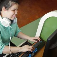 Young Asian blind woman at computer