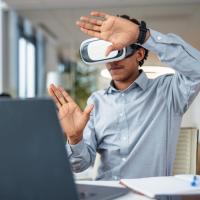 Man at laptop in VR headset