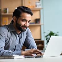 Smiling business man working on laptop