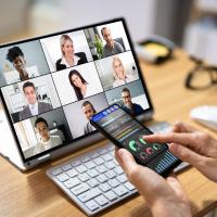 Person on phone and laptop for training meeting