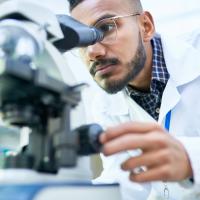 Photo of a scientist looking into a microscope