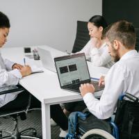 Three office workers with one male worker in wheelchair