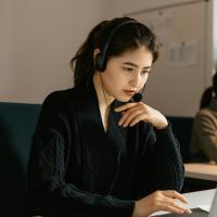 Young woman at laptop on headset