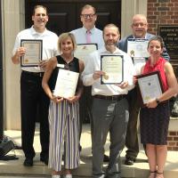 A group of people holding award certificates