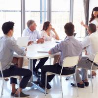 Group of non-employees gather around a table for a training session