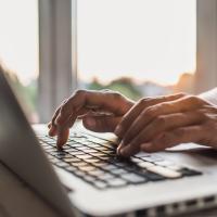 a black person hand working on a laptop 