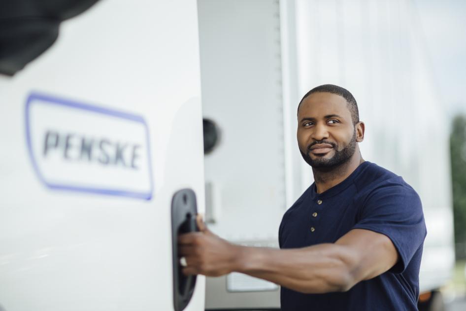 Penske Logistics driver standing by truck