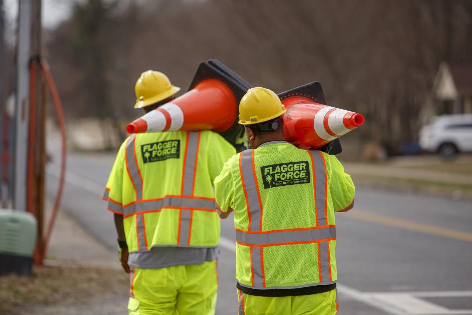 Flagger Forrce workers carrying orange cones