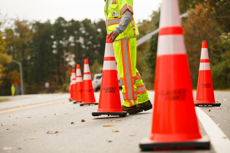 Orange construction cones on road with worker