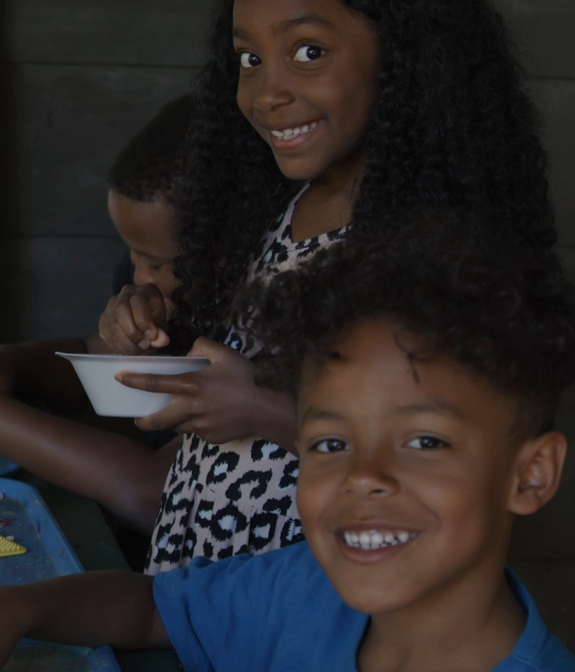 Three young children smiling at camp