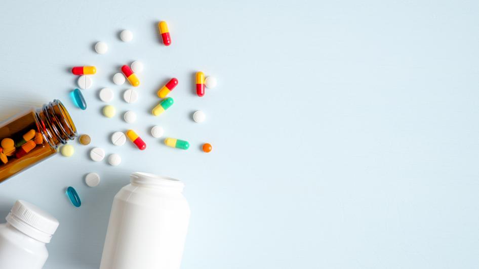 photo of 3 prescription bottle containing medication spilling on a surface 