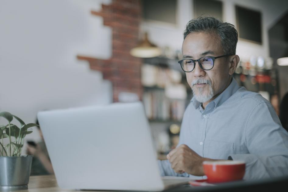 male worker using at laptop in training session 