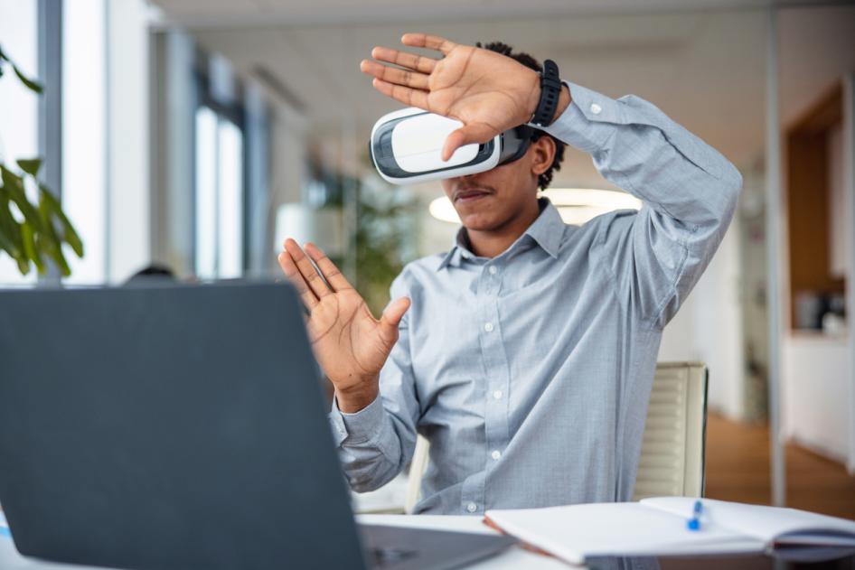 Man at laptop in VR headset