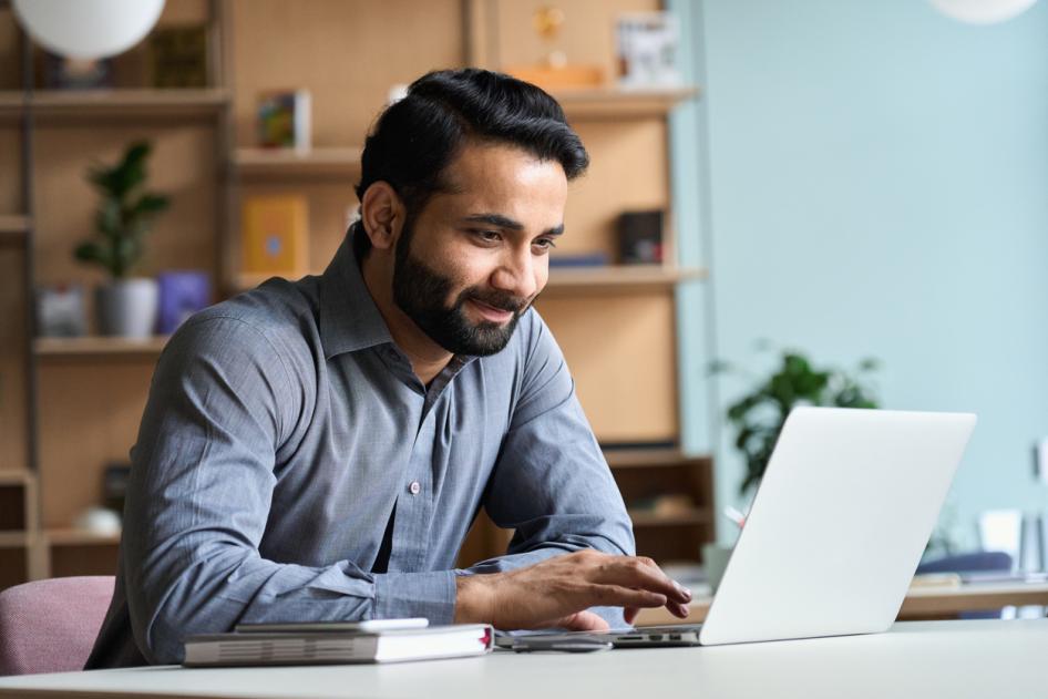 Smiling business man working on laptop