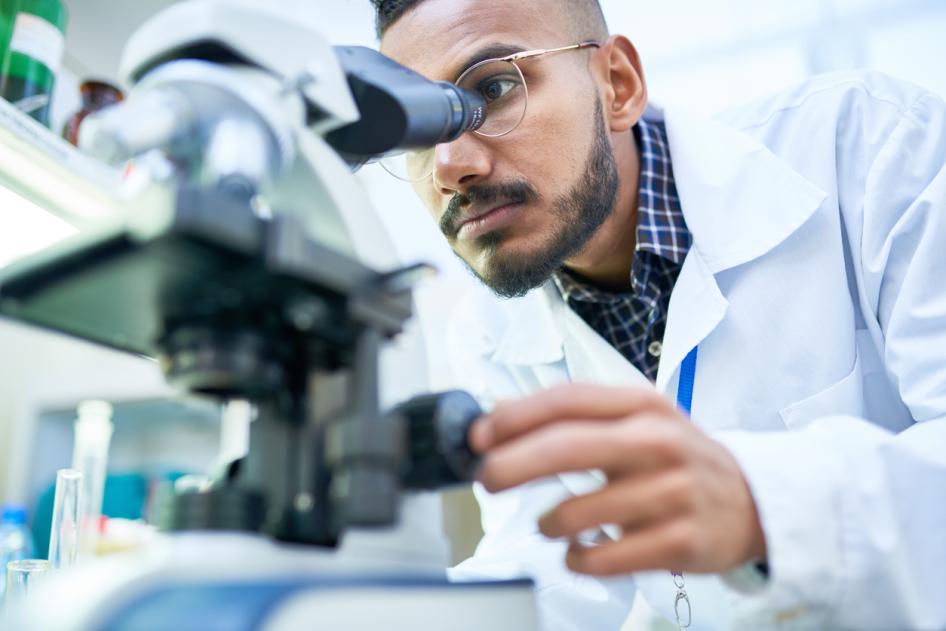 Photo of a scientist looking into a microscope