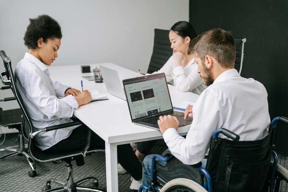 Three office workers with one male worker in wheelchair