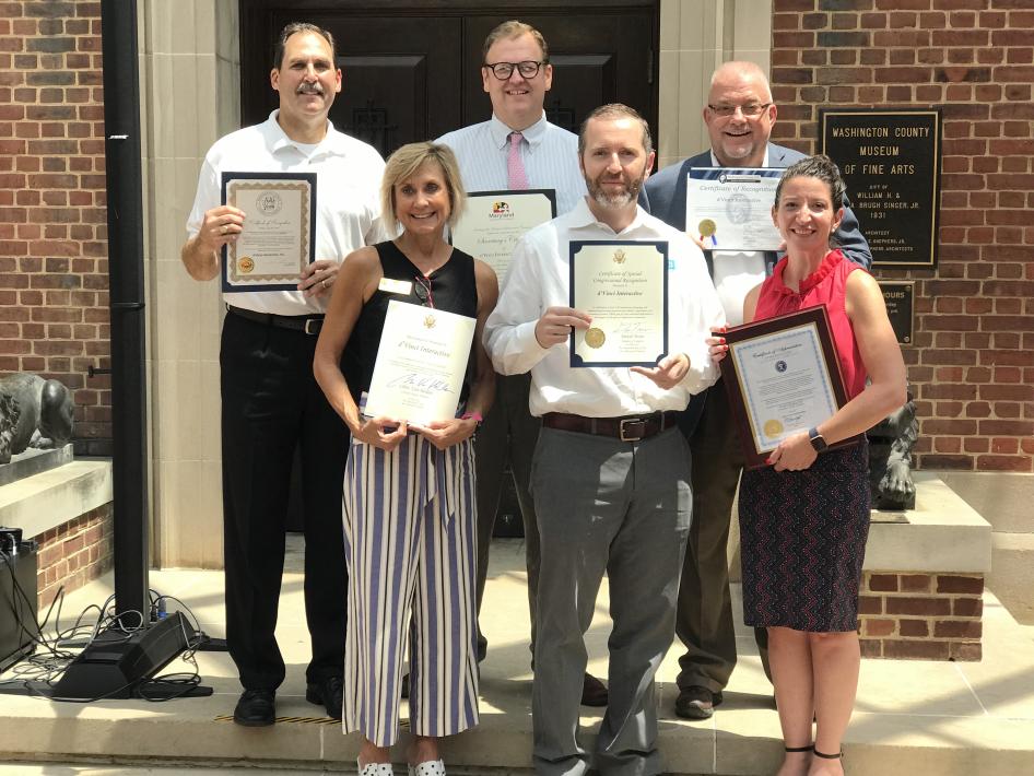 A group of people holding award certificates