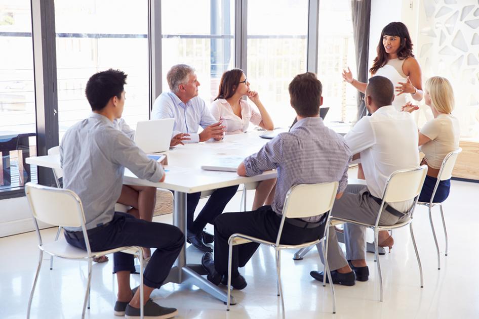 Group of non-employees gather around a table for a training session
